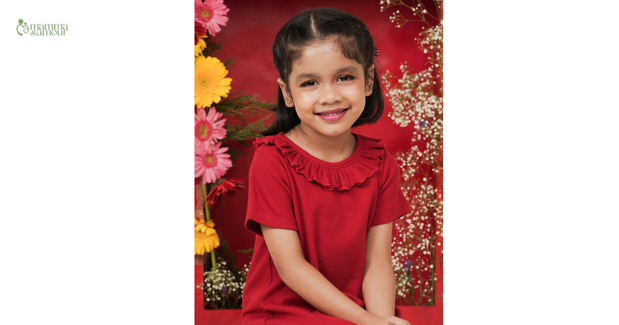 The Ultimate Buying Guide for Baby Girl Dresses by Mamma & Amour, featuring a smiling girl in a cherry red dress.