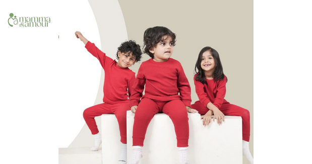 Mamma & Amour three children in matching red organic cotton outfits for Christmas and New Year celebrations