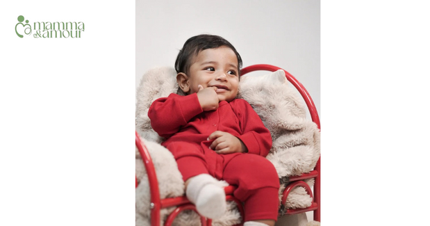 Newborn baby asleep in a soft organic cotton kimono outfit during an at-home photoshoot